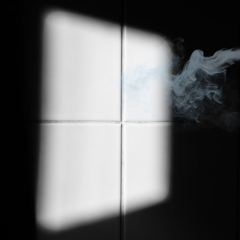 A bright window glowing in a dark room with drifting smoke, black and white