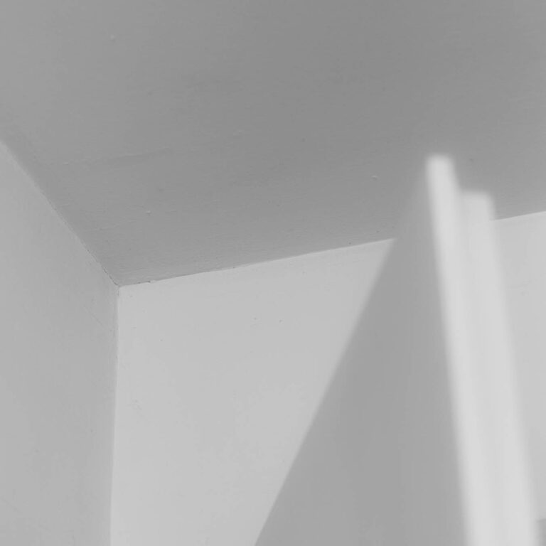 Almost white minimal composition of grey planes and a soft shadow edge