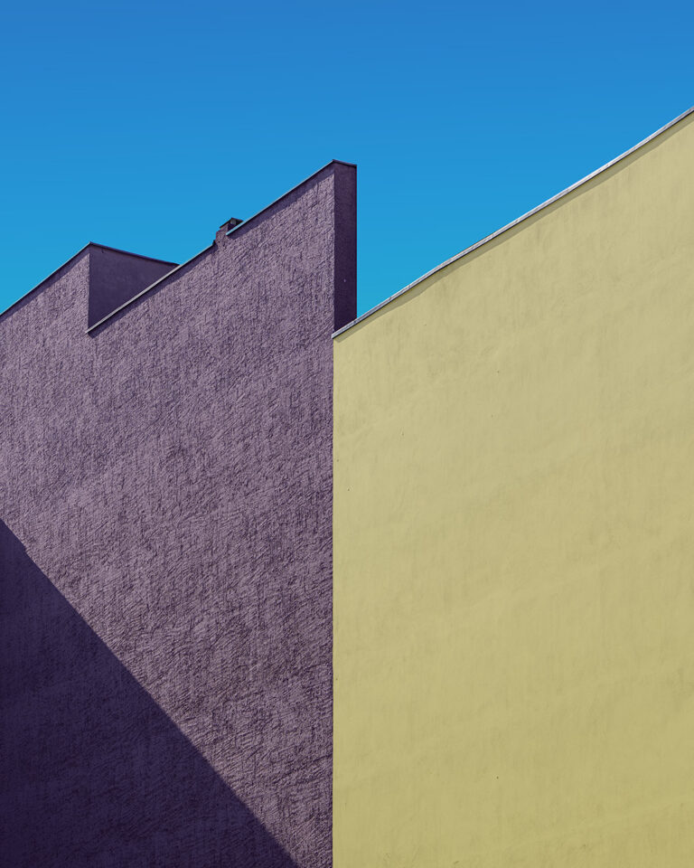 Façade photography: yellow painted wall with a shuttered window, Berlin